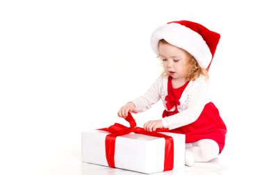 Child dressed as Santa with a Christmas present