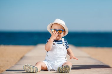 Portrait of a happy child with a hat on the beach