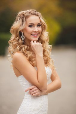 Yaz aylarında parktaki bir fotoğraf için poz gelinlik gelin.