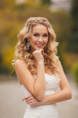 Yaz aylarında parktaki bir fotoğraf için poz gelinlik gelin.