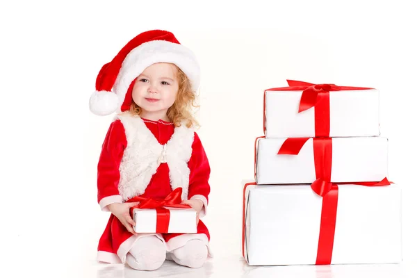 Child dressed as Santa with a Christmas present — ストック写真