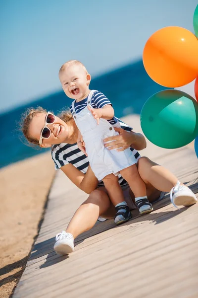 Eine junge Mutter und ihr entzückender kleiner Sohn im Urlaub am Strand — Stockfoto