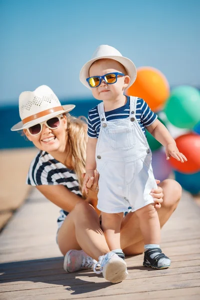 A young mother and her delightful little son on vacation at the beach — Stockfoto