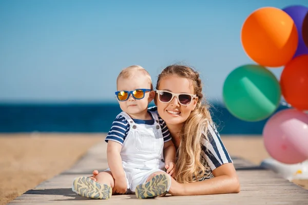 Una joven madre y su encantador hijito de vacaciones en la playa —  Fotos de Stock