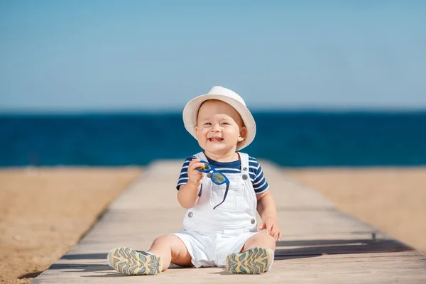 Retrato de uma criança feliz com um chapéu na praia — Fotografia de Stock