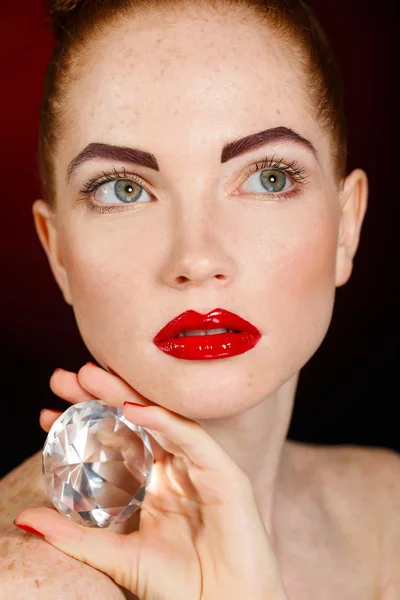 Portrait of a beautiful girl with precious stone isolated on a black background. — Stock Photo, Image