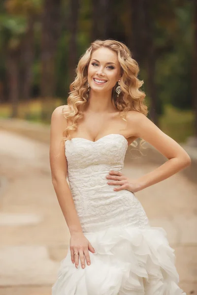 Bride in wedding dress posing for a photograph in the Park in the summer. — Stock Photo, Image