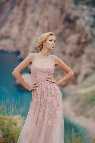 ウェディング ドレスの花嫁上から美しい海の景色と崖の上に立つ — ストック写真