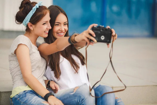 Happy girlfriends in the city with the camera — Zdjęcie stockowe