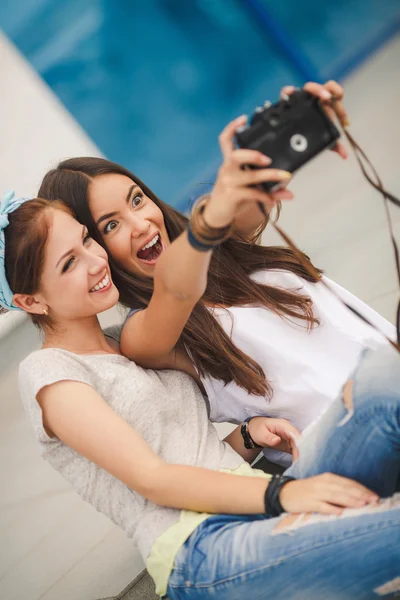 Happy girlfriends in the city with the camera — Stock Photo, Image