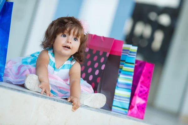 Little girl and lots of colorful bags — Stockfoto