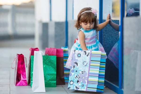 Menina e lotes de sacos coloridos — Fotografia de Stock