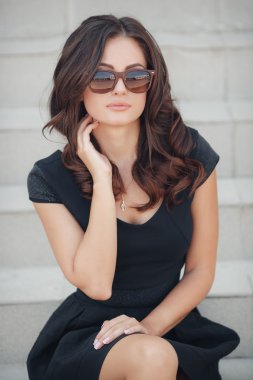 Portrait of the woman sitting on steps with a white handrail