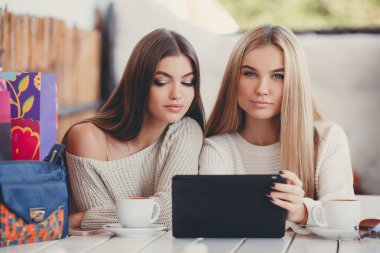 Girlfriends consider photos on the digital tablet