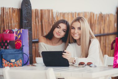 Girlfriends consider photos on the digital tablet