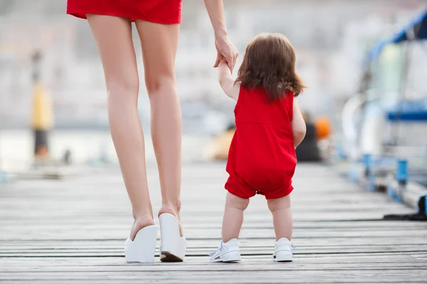 Moeder en kleine dochter wandelen langs de waterkant — Stockfoto