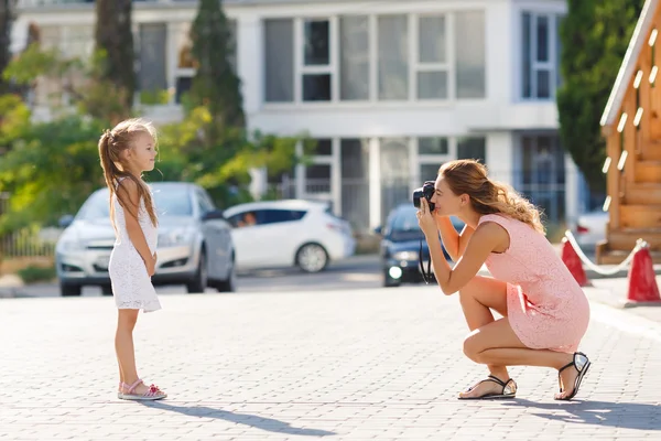 Mamá fotografía a su hija en la calle en la ciudad en el verano —  Fotos de Stock