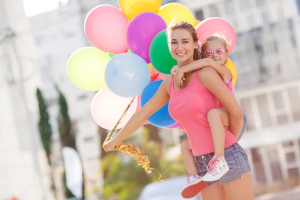 Mère et enfant avec des ballons colorés — Photo