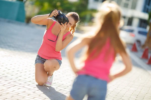 Mom photographs her daughter on the street in the city in the summer — Stock Fotó