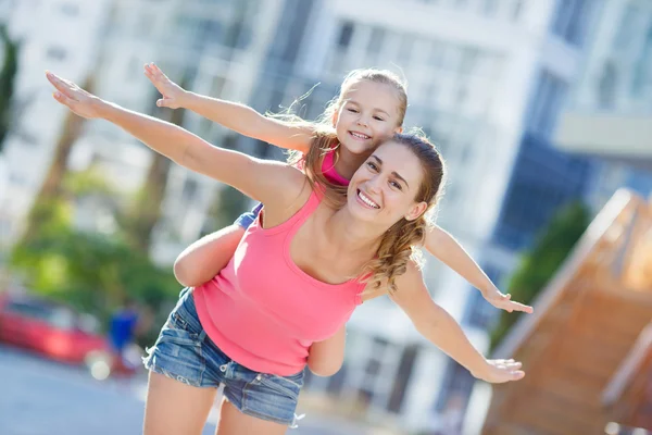 Mãe feliz e sua filha brincando ao ar livre no verão . — Fotografia de Stock