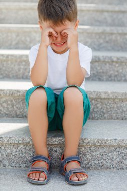 The boy sitting on the stairs in the underpass