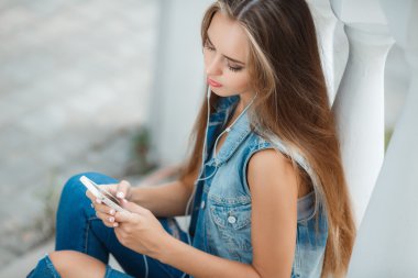 Girl listening to music,sitting on the steps