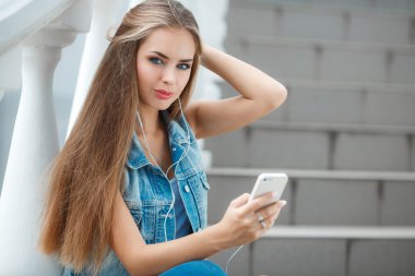 Girl listening to music,sitting on the steps