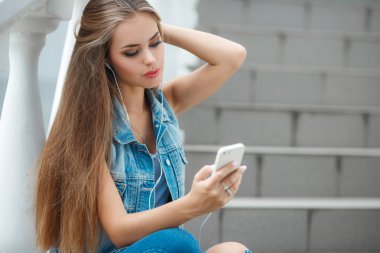 Girl listening to music,sitting on the steps