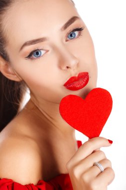 Portrait of a beautiful girl with a red heart in his hand