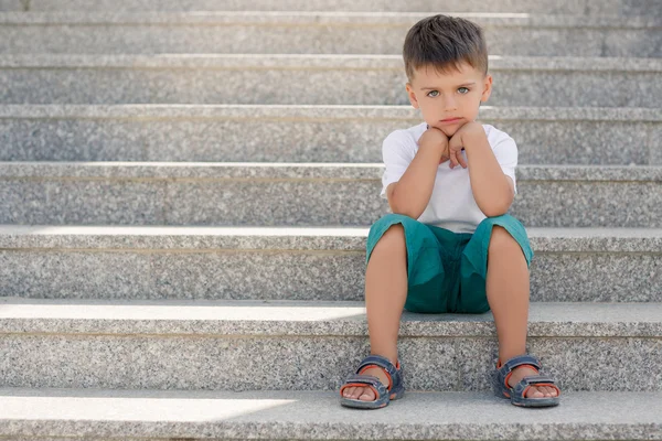Мальчик сидит на лестнице в подземном переходе — стоковое фото