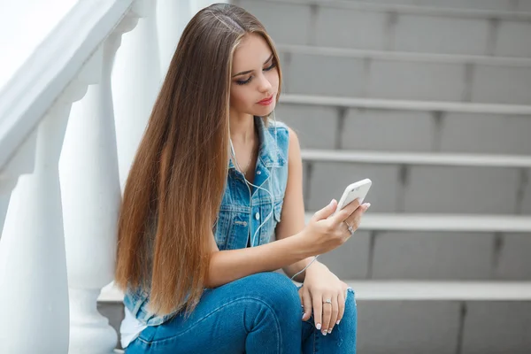 Chica escuchando música, sentada en las escaleras —  Fotos de Stock