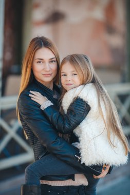 Mother holding daughter in her arms,standing in the fresh air