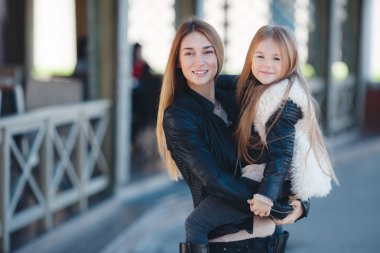 Mother holding daughter in her arms,standing in the fresh air