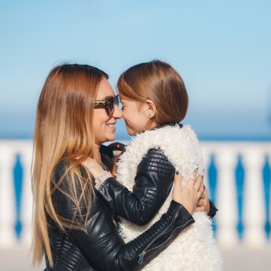 Mom and daughter spend time walking near the sea