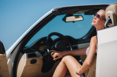 Beautiful woman in a white convertible car.