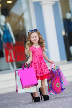 Little girl with shopping bags goes to the store