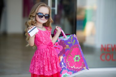 Little girl with shopping bags goes to the store