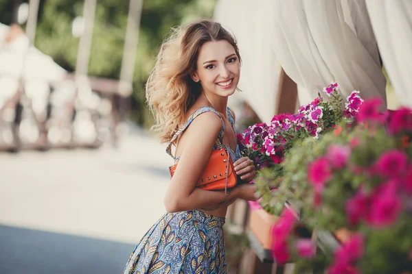 Portrait of a pretty woman next to vases of flowers — Stockfoto