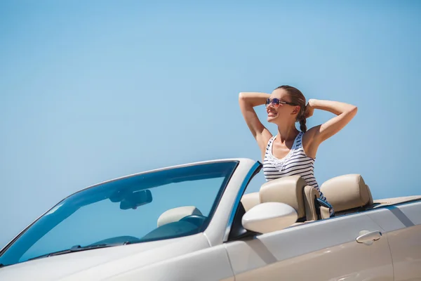 Beautiful woman in a white convertible car. — Stock Fotó