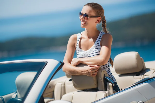 Mulher bonita em um carro branco conversível . — Fotografia de Stock