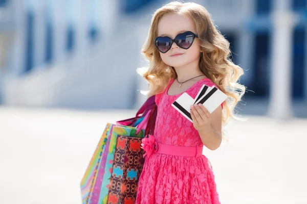 Um jovem comprador com sacos coloridos e cartão de crédito — Fotografia de Stock