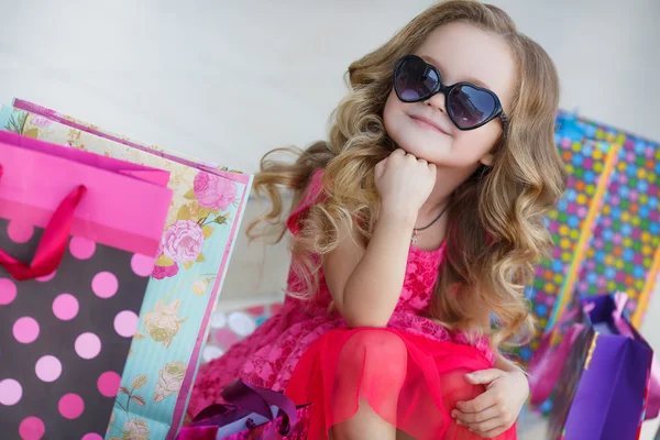 Kleines Mädchen mit Einkaufstüten geht in den Laden — Stockfoto