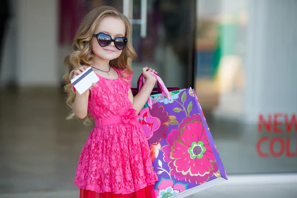 Little girl with shopping bags goes to the store — 스톡 사진