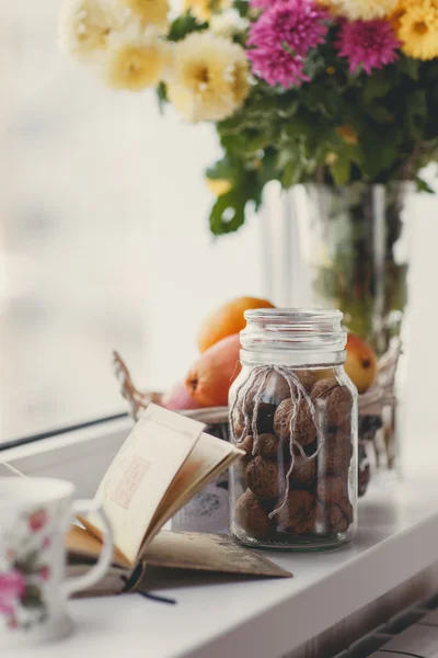 Herbst-Stillleben mit Nüssen und Zitrusfrüchten auf der weißen Fensterbank. — Stockfoto