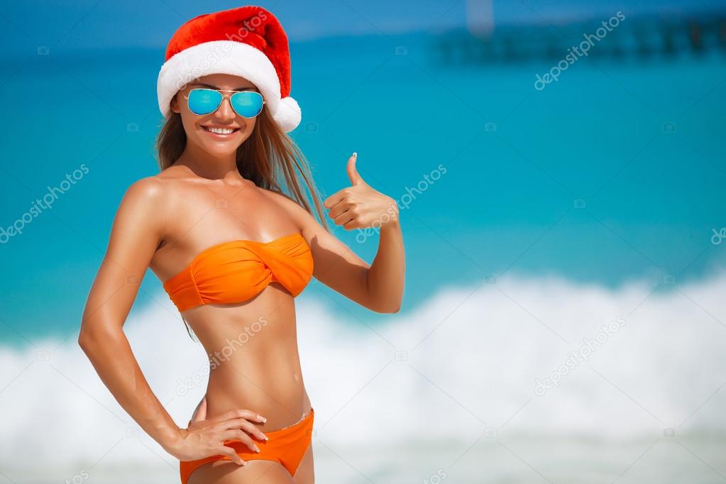 Maiden in orange bikini and hat of Santa Claus