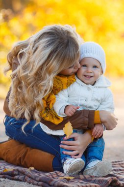 Mom and daughter resting in a park in autumn