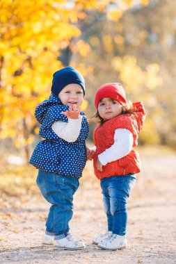 Little girls - girlfriends walk in the park.