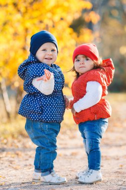 Little girls - girlfriends walk in the park.