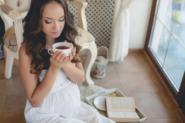 Uma jovem grávida com uma xícara de chá . — Fotografia de Stock