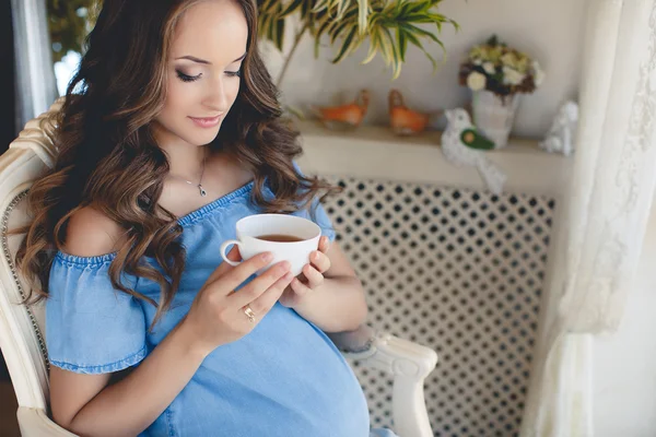 Μια νεαρή έγκυο γυναίκα με ένα φλιτζάνι τσάι. — Φωτογραφία Αρχείου